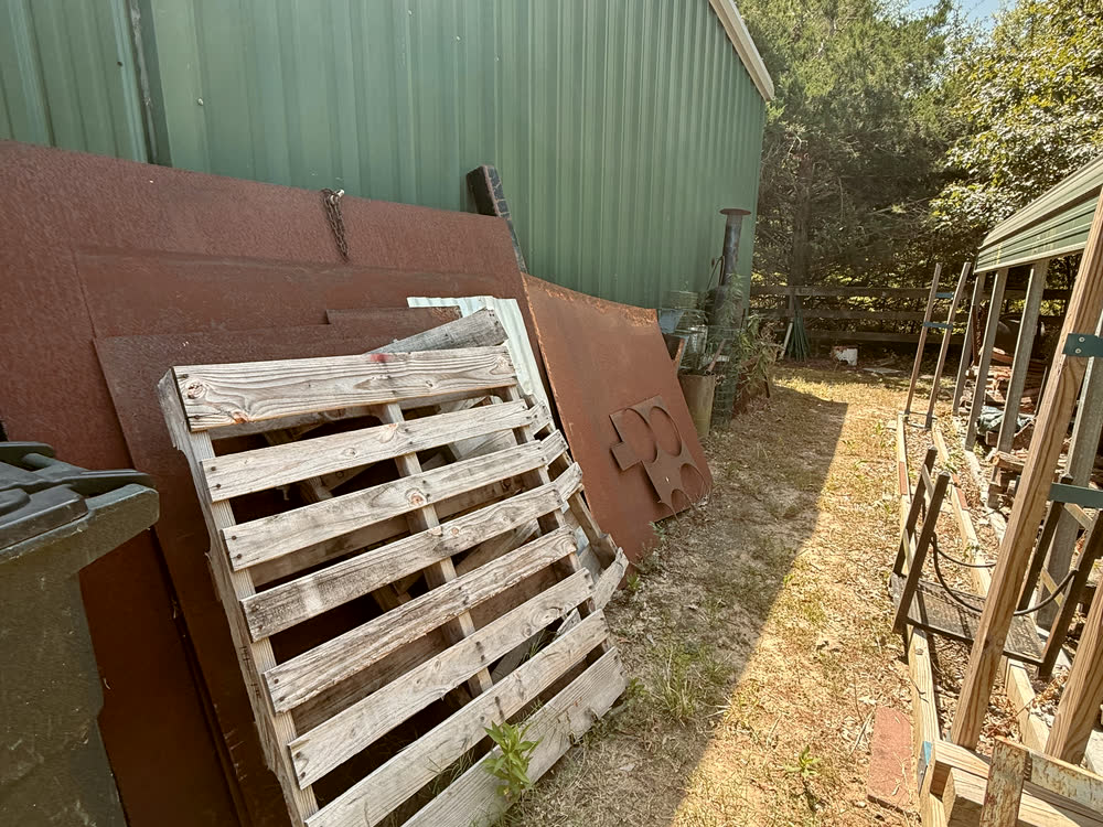 Pallets and sheet metal by the shed